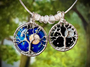 Two tree-themed pendants on a blurred green background